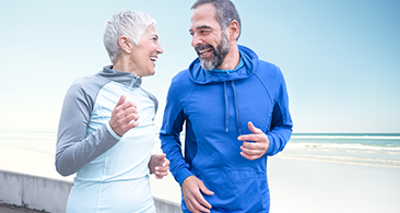 Couple running Older couple running outside in training gear