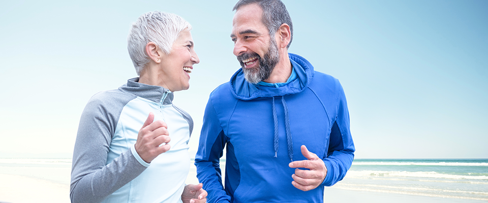 Couple running Older couple running outside in training gear